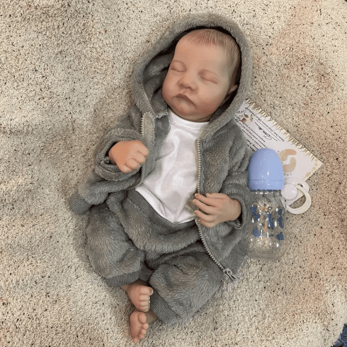 Bebê Reborn Heitor, boneco realista de 1,2kg com silicone, olhos fechados, cabelo pintado e acessórios. Perfeito para crianças 3+, fomenta cuidado e imaginação!