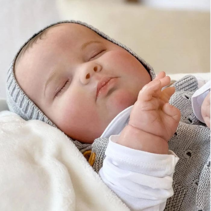 Bebê Reborn João Guilherme 60cm, boneco realista de silicone com olhos fechados, cabelo pintado e acessórios. Perfeito para crianças 3+, fomenta cuidado e imaginação!