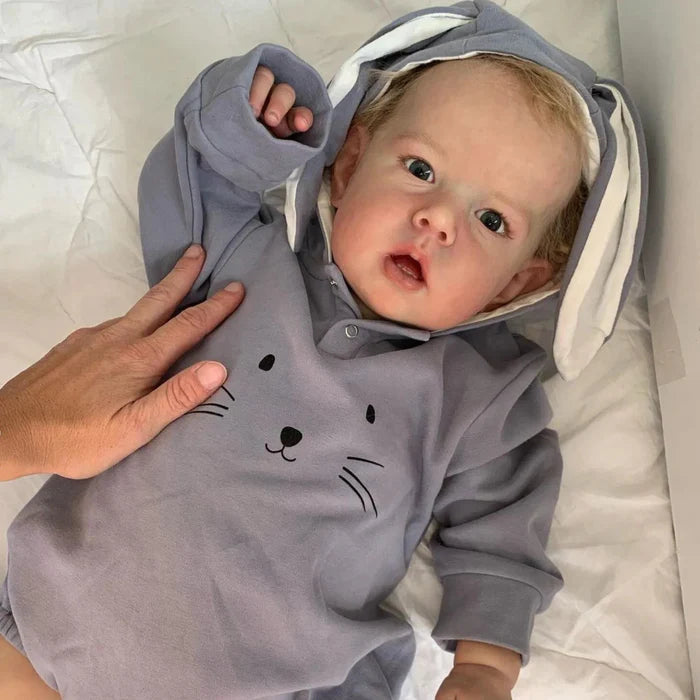 Bebê Reborn Enzo, boneco realista de 1,2kg com corpo macio, olhos vivos, cabelo enraizado e acessórios. Perfeito para crianças 3+, inspira afeto e imaginação!