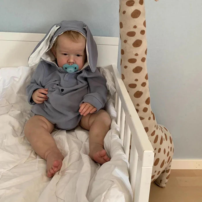 Bebê Reborn Enzo, boneco realista de 1,2kg com corpo macio, olhos vivos, cabelo enraizado e acessórios. Perfeito para crianças 3+, inspira afeto e imaginação!