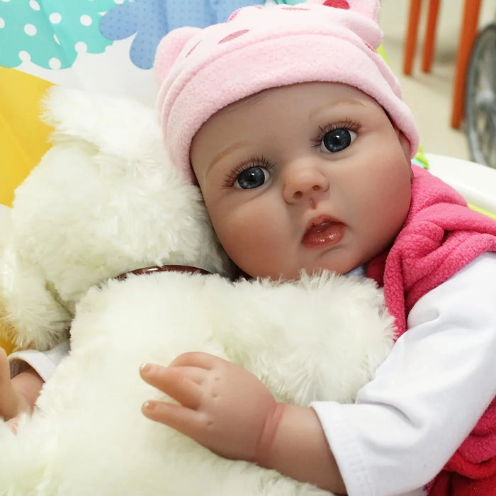 Bebê Reborn Isis 55cm, boneca realista com corpo macio, olhos vivos, cabelo fio a fio e acessórios. Perfeita para crianças 3+, traz magia e ternura às brincadeiras!