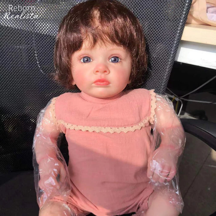 Bebê Reborn Rebeca 55cm, boneca realista com corpo macio, olhos vivos, cabelo fio a fio e acessórios. Perfeita para crianças 3+, traz magia e carinho às brincadeiras!