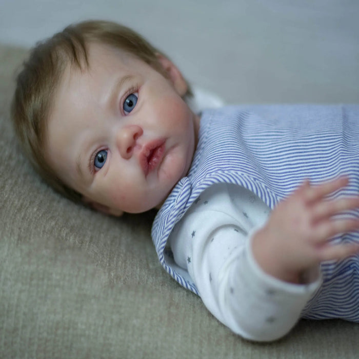 Bebê Reborn Samuel 55cm, boneco realista com corpo macio, olhos vivos, cabelo fio a fio e acessórios. Perfeito para crianças 3+, traz magia e ternura às brincadeiras!