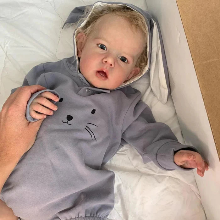 Bebê Reborn Enzo, boneco realista de 1,2kg com corpo macio, olhos vivos, cabelo enraizado e acessórios. Perfeito para crianças 3+, inspira afeto e imaginação!