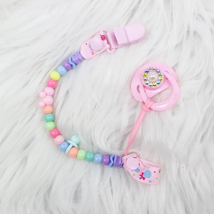 Chupeta Magnética Rosa Arco-íris Bebê Reborn, 5cm, plástico ABS seguro. Design colorido para bonecas, 14+, adiciona charme e delicadeza à coleção com fixação magnética!