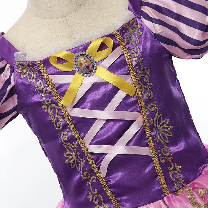 Fantasia Infantil Princesa Rapunzel com vestido, coroa, luvas, varinha e cabelo, em malha, algodão e poliéster. Perfeita para crianças em festas e eventos encantados!